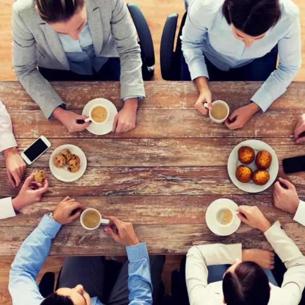 business-people-break-team-work-concept-close-up-creative-team-meeting-drinking-coffee-with-muffins-during-lunch-office
